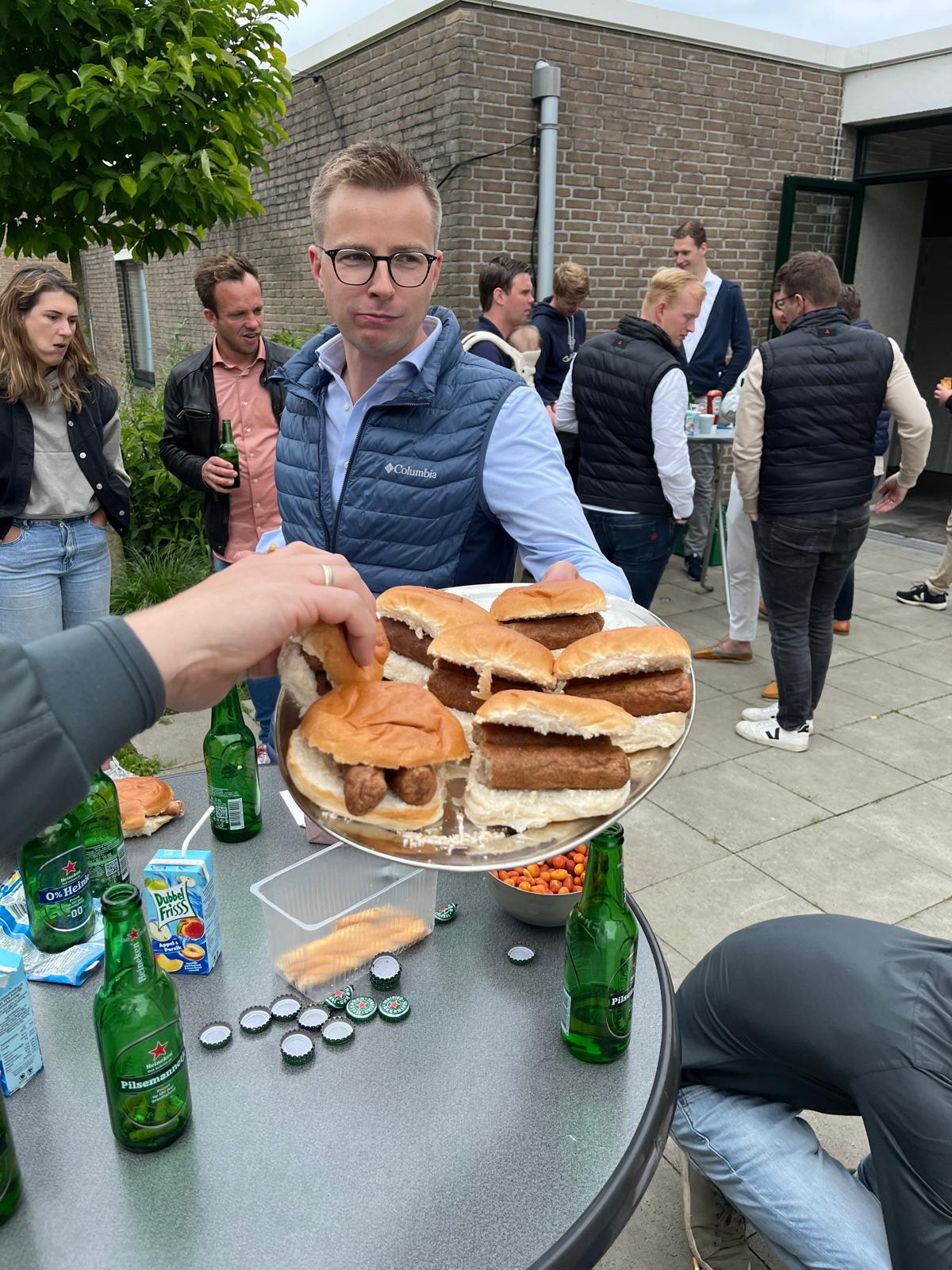 KV-leider Henri Rebel met een schaal frikandelbroodjes tijdens een leiding-borrel, juni 2024